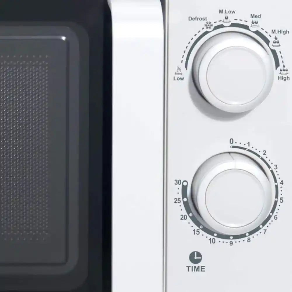 White Studio Collection 20 litre 700W manual microwave showing control panel with temperature dial, timer knob, and defrost settings, displayed next to microwave interior cavity