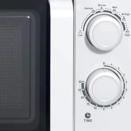 White Studio Collection 20 litre 700W manual microwave showing control panel with temperature dial, timer knob, and defrost settings, displayed next to microwave interior cavity