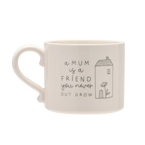 Cream ceramic mug with curved handle featuring handwritten-style text reading "a MUM is a FRIEND you never OUT GROW" and a line-drawn illustration of a house with a door and flower on the right side