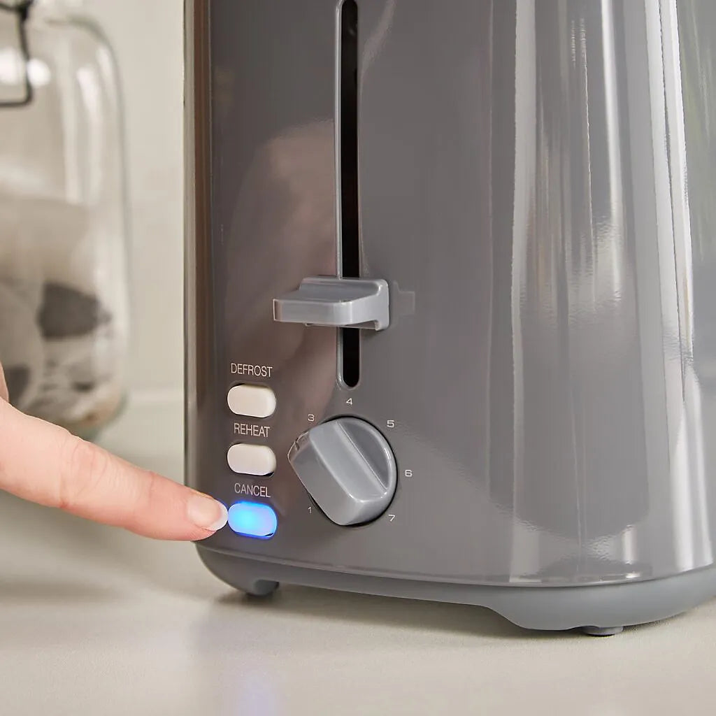 Person's finger pressing the blue start button on a grey Morphy Richards Equip 2 slice toaster with defrost, reheat and cancel buttons and a numbered browning dial