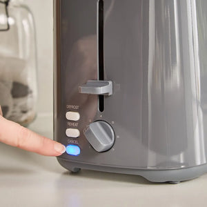 Person's finger pressing the blue start button on a grey Morphy Richards Equip 2 slice toaster with defrost, reheat and cancel buttons and a numbered browning dial