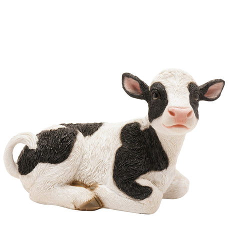 Resin figurine of a black and white cow on a white background