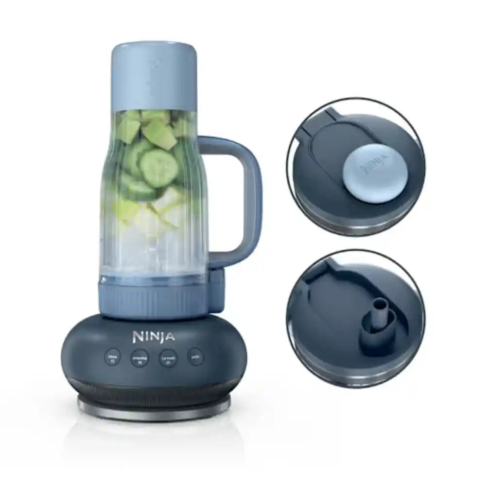 Ninja BlendBOSS Tumbler Blender in Cyberspace grey with a clear blending pitcher containing sliced cucumbers, featuring a dark grey base with control buttons and two interchangeable lids shown on the right side
