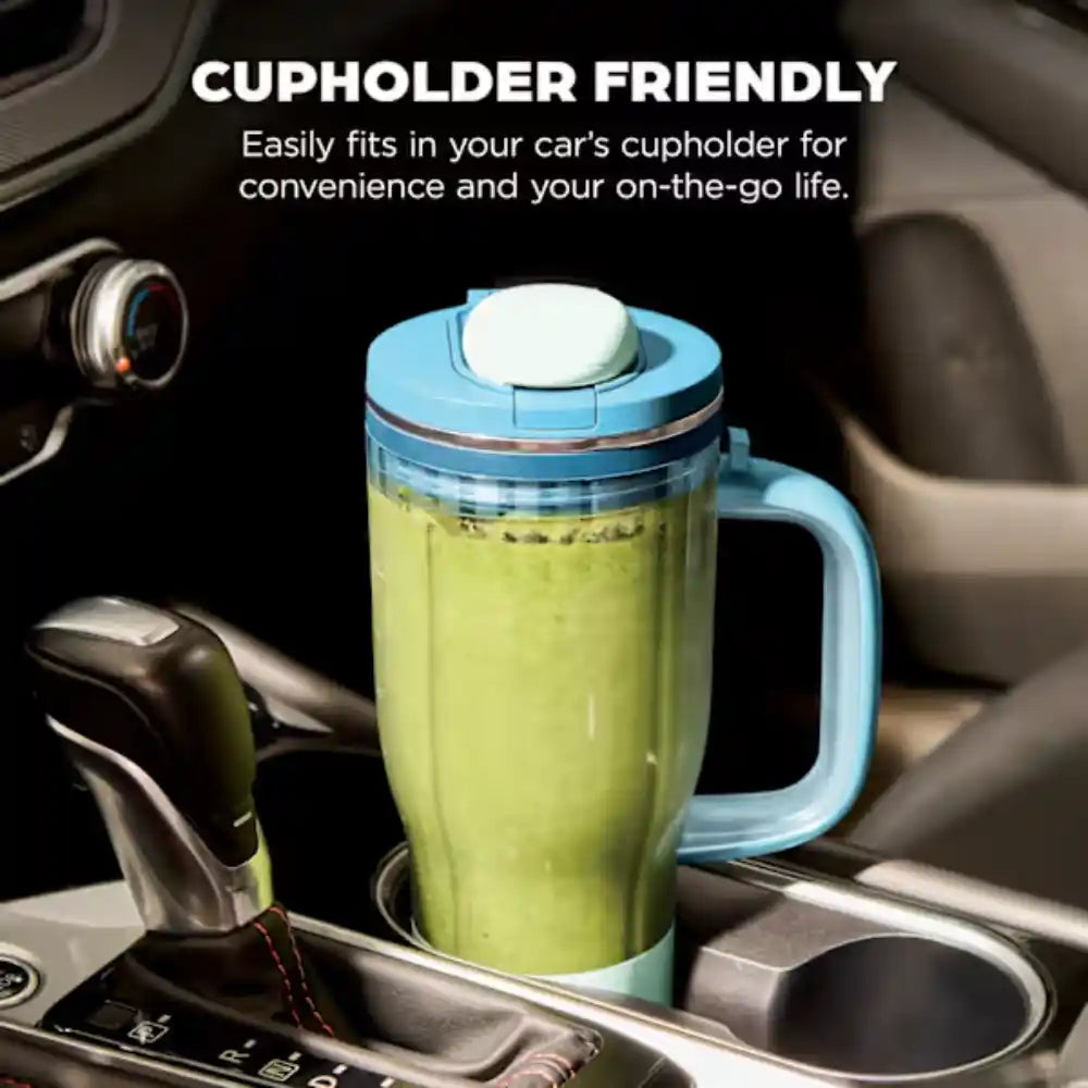Light blue Ninja BlendBOSS tumbler blender filled with green smoothie, positioned in a car cupholder between the front seats, demonstrating cupholder-friendly design for on-the-go blending