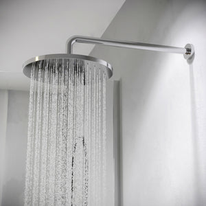 Chrome rainfall showerhead with water spray mounted on angled arm against white bathroom wall, modern minimalist design