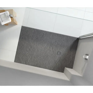 Overhead view of a modern grey slate-effect rectangular shower tray installed in a white tiled bathroom with chrome fixtures and white raised edges