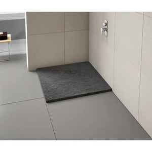 Modern bathroom shower enclosure featuring a dark grey slate-effect rectangular shower tray with chrome fixtures on cream tile walls and light grey floor tiles