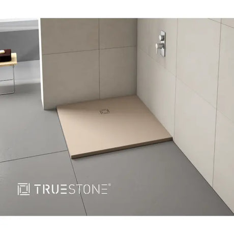 Merlyn Truestone rectangular shower tray in cream with integrated waste, installed in modern bathroom with cream wall tiles and chrome mixer tap