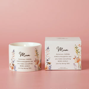 Candle and packaging with 'Mum' text and floral design on a pink background