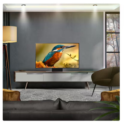 LG 43 inch QNED87 MiniLED 4K Smart TV displaying a kingfisher bird image in a modern living room with grey walls, white media console, dark grey sofa, brass floor lamp and contemporary furniture