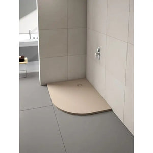 Merlyn Truestone curved offset quadrant shower tray in cream beige with dark trim installed in modern bathroom with large format wall tiles and chrome fixtures