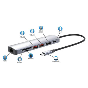 Manhattan USB-C 7-in-1 docking station with silver aluminum body showing labeled ports including USB 3.2 Gen 2, HDMI 4K@60Hz, PD In, RJ45 ethernet, SD Card reader, and MicroSD slot, connected to notebook via USB-C cable
