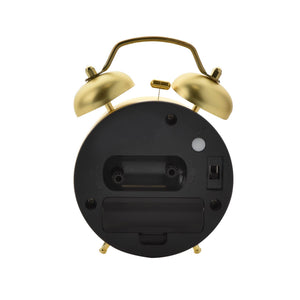 Back view of a black and brass twin bell alarm clock with Harry Potter Hogwarts Crest design, featuring a circular black face, mechanical movement, battery compartment, and gold-tone metal bells and handle on white background