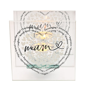 Frosted glass tealight holder with heart cutout pattern and warm LED light inside, featuring handwritten-style "mum" text in black with heart symbol, surrounded by circular text including words like "Everlasting support" and "Best friend" in black typography, set against white background